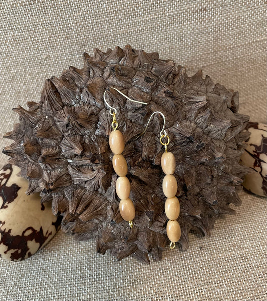 A pair of beige tagua nut dangle earrings with gold accents autumn spring